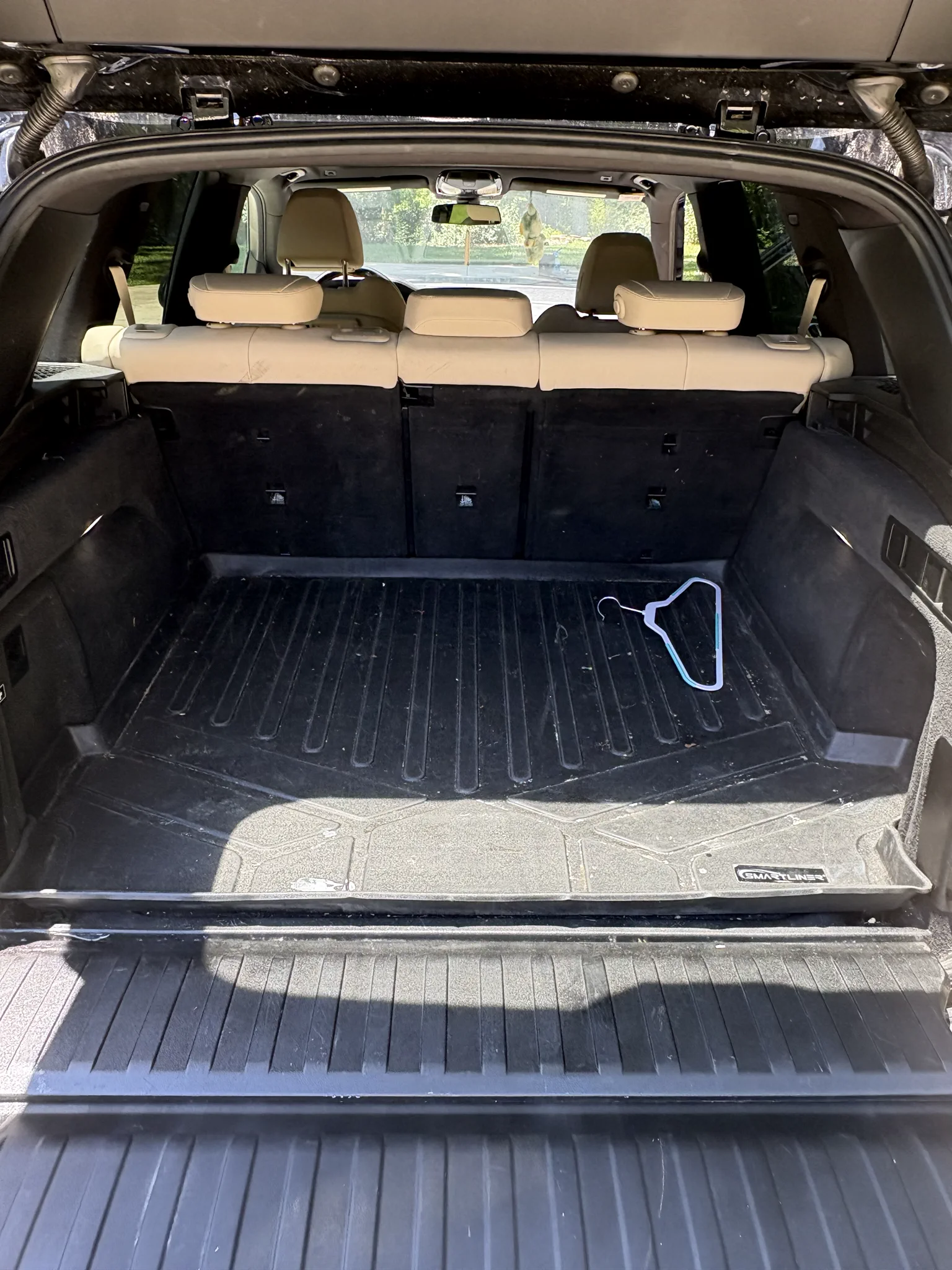BMW X5 cargo area before detailing with loose debris and daily-use items