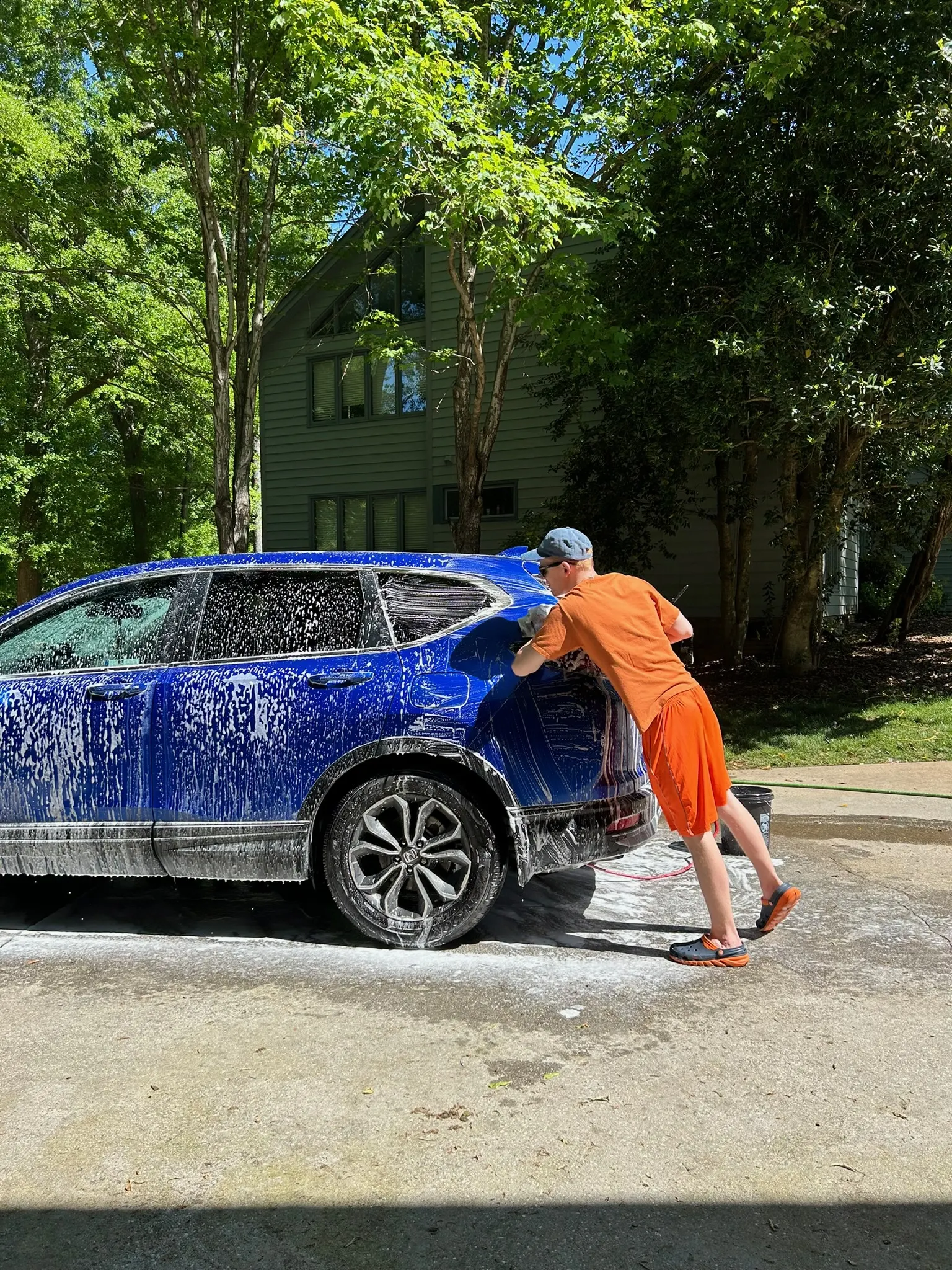 Alexander hand washing a blue SUV