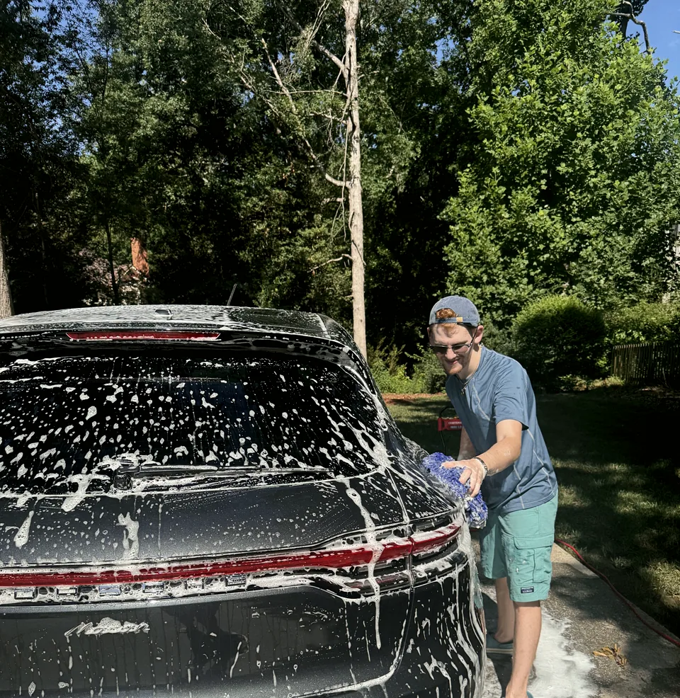 Alexander Wolf hand washing a Porsche in River Point