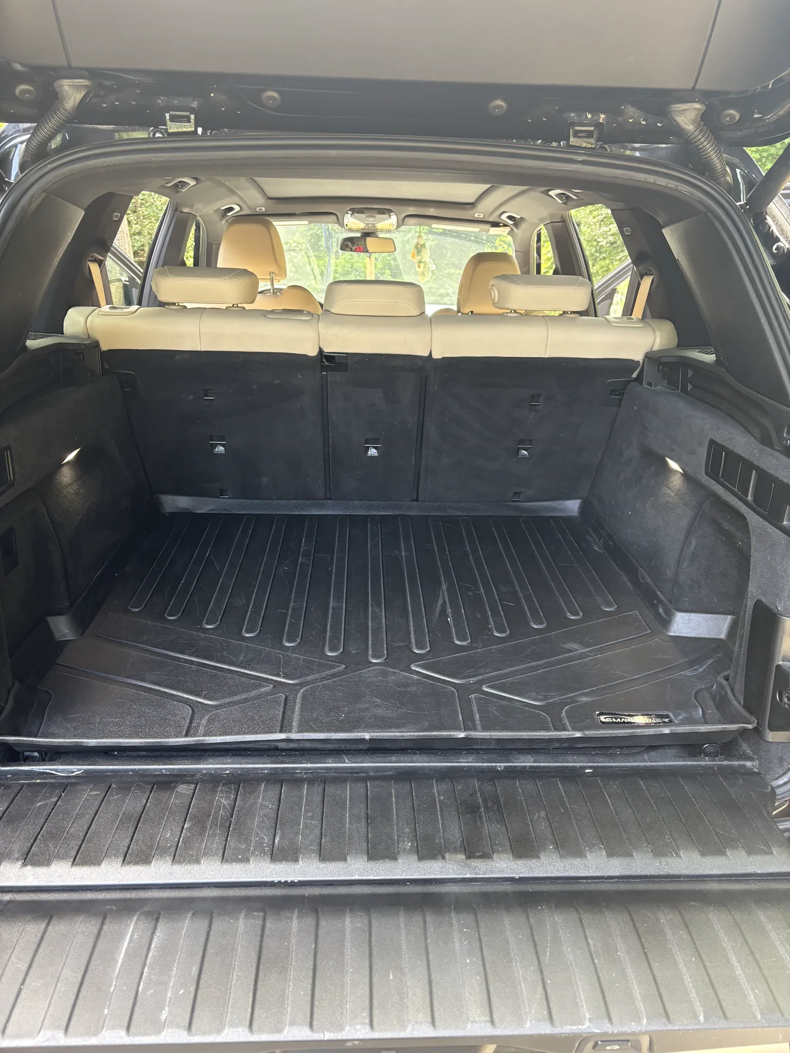 BMW X5 cargo area after detailing with debris removed and surfaces reset